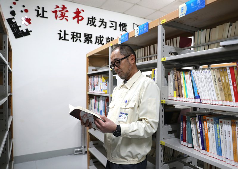 12月8日，日本專家小辻啓一在青島松下電子部品（保稅區(qū)）有限公司的書屋里查閱資料。張進(jìn)剛攝