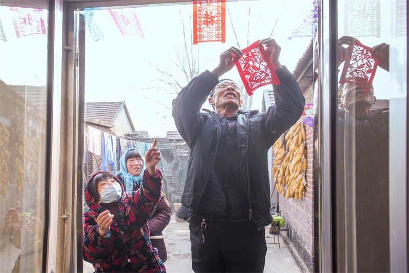 圖為來逢強正在張貼“過門箋”。陳光金攝