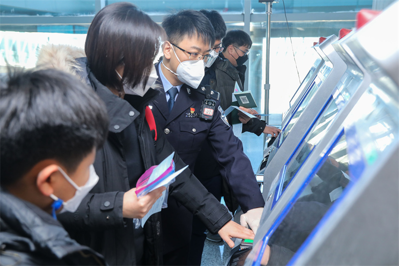 1月9日，山東出入境邊防檢查總站青島機場邊檢站民警引導旅客采集入境通關信息。解豪攝