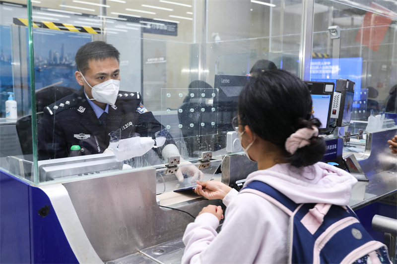 1月9日，山東出入境邊防檢查總站青島機(jī)場邊檢站民警為入境旅客辦理通關(guān)手續(xù)。解豪攝