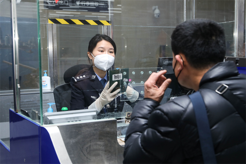 1月9日，山東出入境邊防檢查總站青島機場邊檢站民警為入境旅客辦理通關(guān)手續(xù)。解豪攝