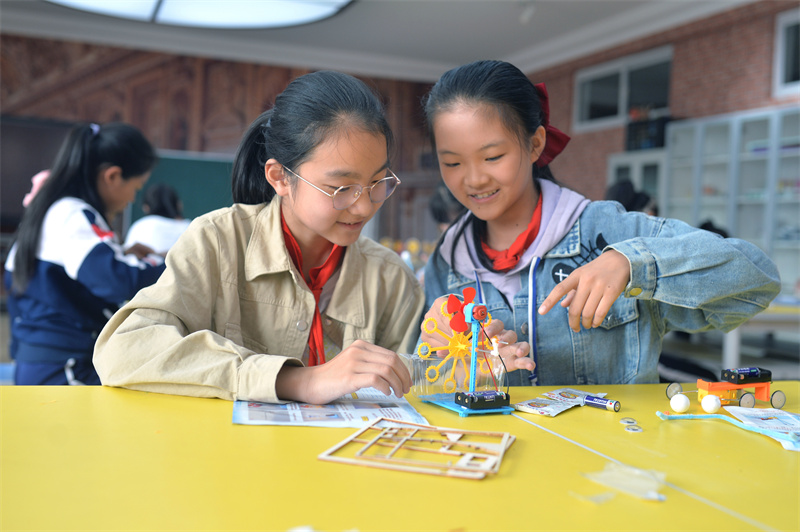 2024年10月10日，在山東青島普新小學(xué)的手工課堂上，兩名學(xué)生在安裝制作泡泡機(jī)。
