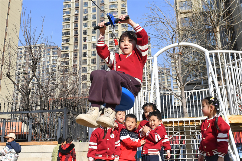 小朋友在山東青島高安路幼兒園開展的新學期“悅動健康”主題課堂上進行滑索鍛煉。王海濱攝