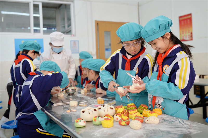 2025年3月7日，兩名學生在山東青島市北實驗小學開展的婦女節“我為媽媽做花饃”主題活動上學做刺猬花饃。王海濱攝