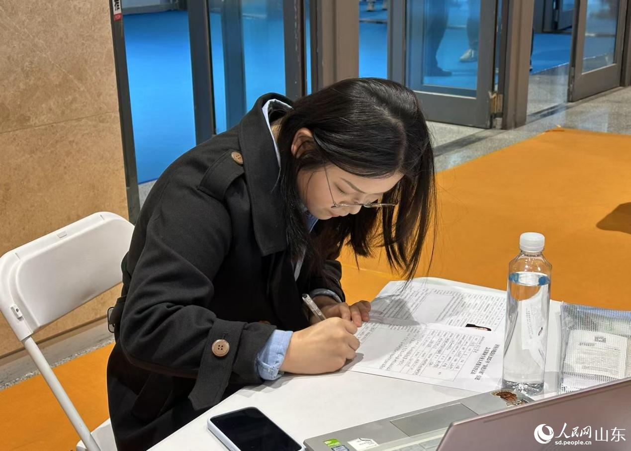 求職者達(dá)成就職意向，現(xiàn)場填寫崗位登記表。人民網(wǎng) 喬姝攝