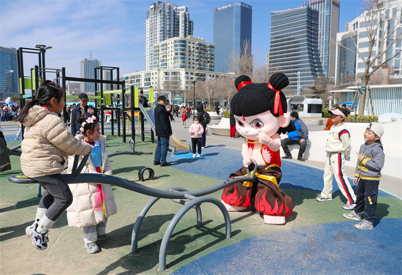 3月29日，在山東青島嶗山區石老人浴場，“哪吒”在和小朋友壓蹺蹺板。