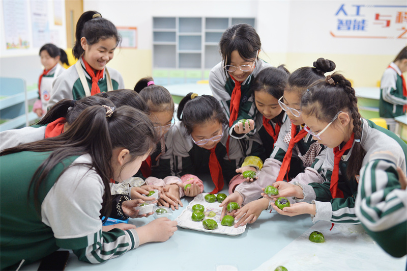 學生們在山東省青島市市北區普新小學開展的民俗迎清明活動上將做好的青團分類包裝。王海濱攝