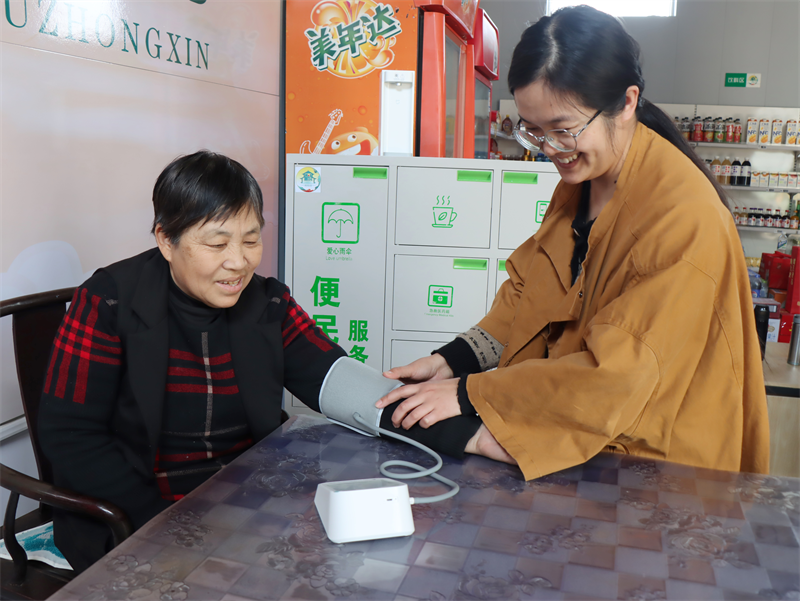 社區(qū)居民在“服務(wù)驛站”測量血壓