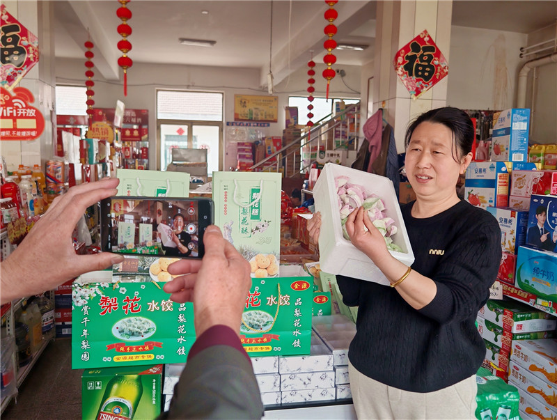圖為志愿者為張蘭英錄制產品推介視頻
