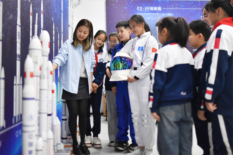 在山東省青島市市北區開平路小學開展的“中國航天日”科普活動上，老師在為學生科普長征運載火箭模型。