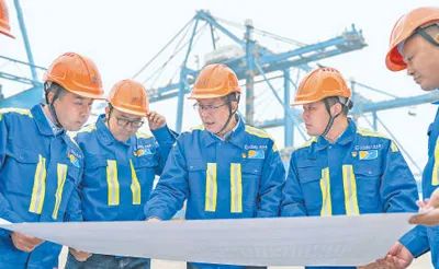 張連鋼（中）與團(tuán)隊(duì)成員討論自動化碼頭設(shè)計方案。資料圖片