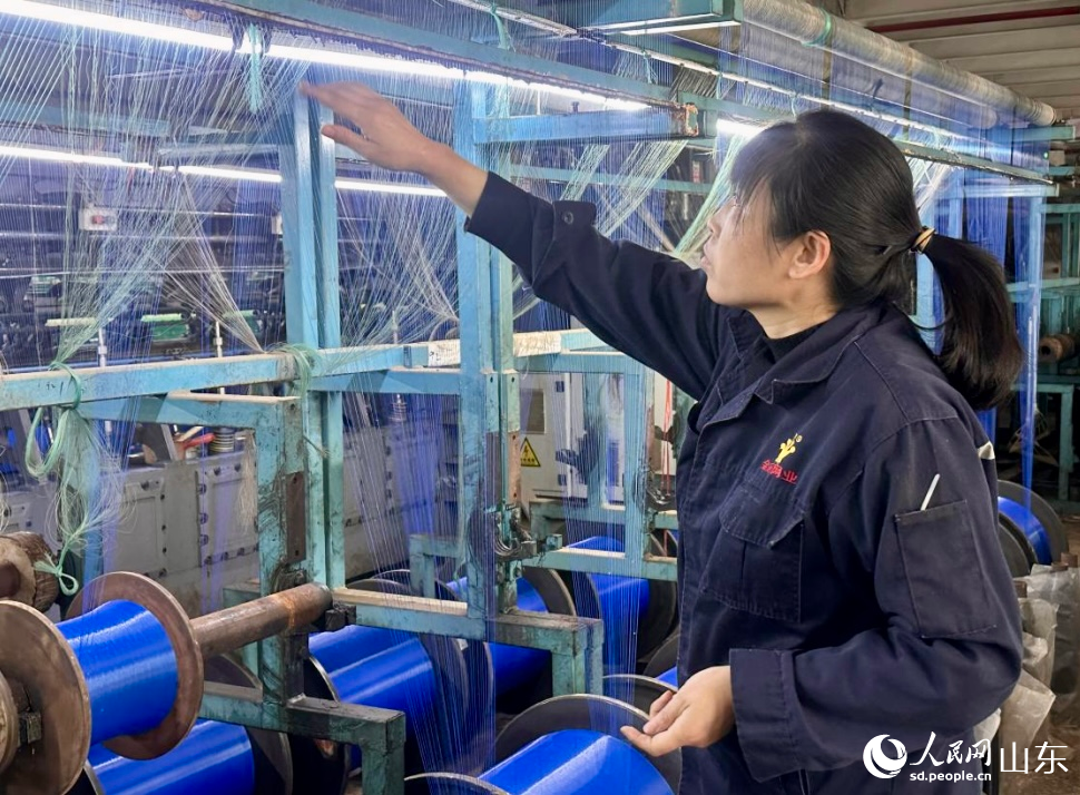 丁安菊正在織機(jī)前忙碌。 人民網(wǎng) 喬姝攝