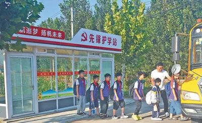 圖為蒙陰縣常路鎮開展“黨員同做一件事·先鋒護學站”活動，黨員在引導孩子們候車上車。張紀增攝