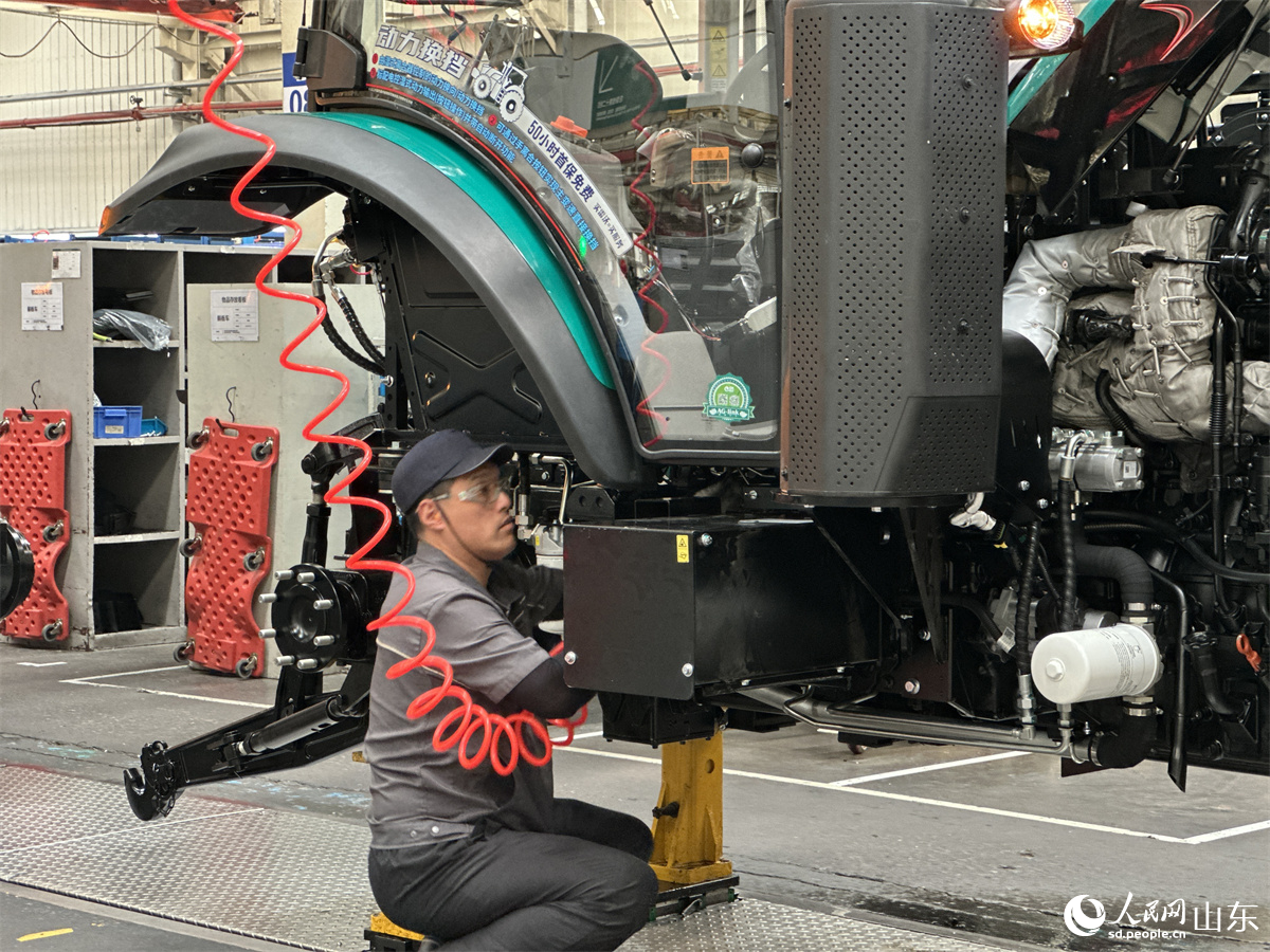 濰柴雷沃智慧農(nóng)業(yè)科技股份有限公司拖拉機工廠總裝車間，工人正在裝配智能拖拉機。人民網(wǎng) 喬姝攝