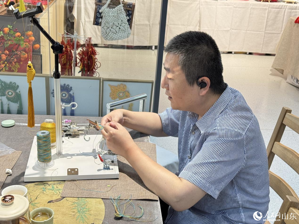 手藝人正在通過精湛的技藝?yán)K編出蓮花瓣的弧度。人民網(wǎng) 莊潤澤攝