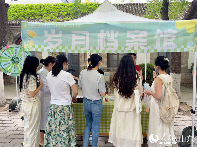 “歲月檔案館”攤位前，同學們踴躍答題。人民網 莊潤澤攝
